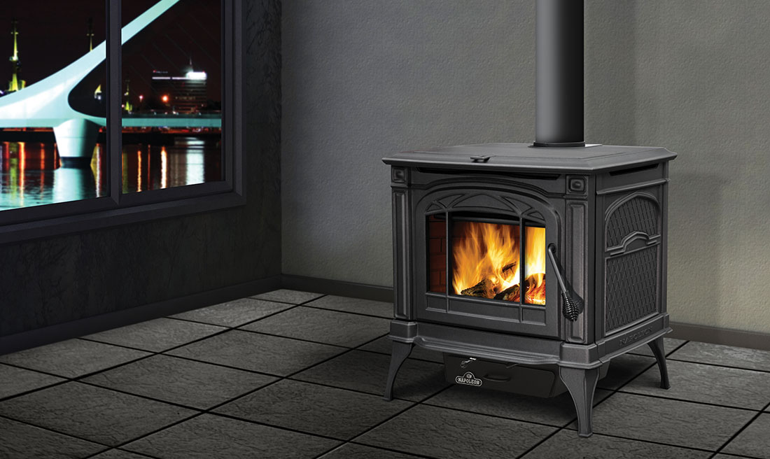 Napoleon BANFF Series 1400C Cast Iron EPA Wood Stove on tile with large windows overlooking water to the left